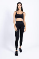 Modella che indossa i leggings push-up neri con top coordinato