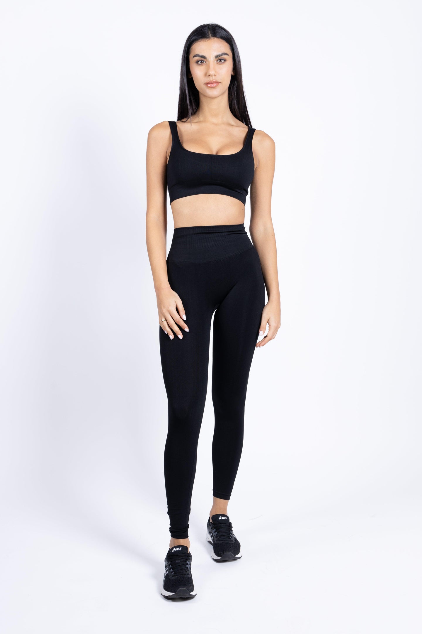 Modella che indossa i leggings push-up neri con top coordinato